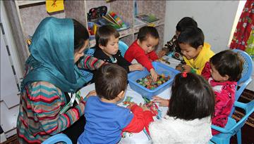 Afghan mothers study alongside their young children to improve their literacy